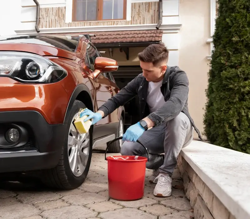 Lavage auto à domicile Larchamp : professionnel intervenant sur un véhicule